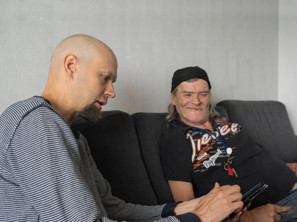 Työntekijä näyttää asiakkaalle tietoja puhelimelta.